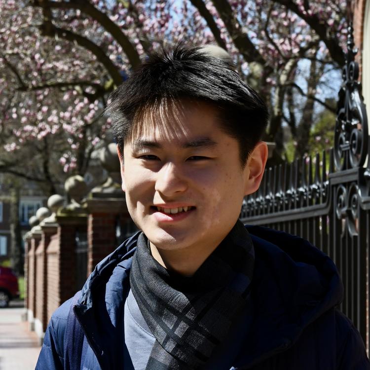 Yizhe under cherry blossoms with smile