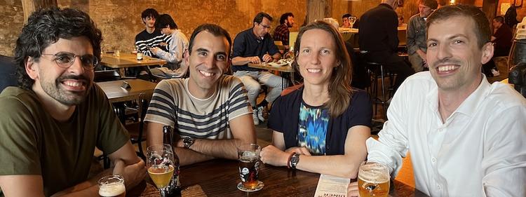 Four past lab members at a bar table 